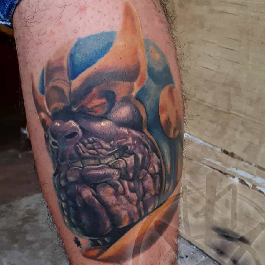 A bold, colorful Thanos tattoo featuring intricate details, deep shading, and his iconic helmet
