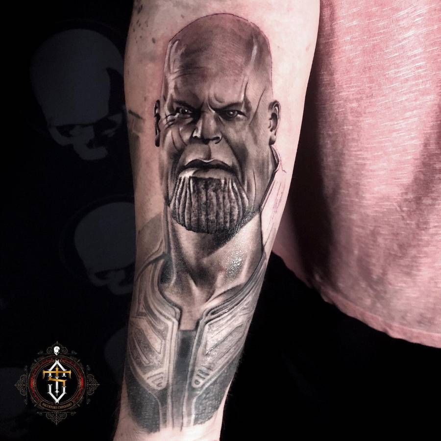 A highly detailed black and gray tattoo of Thanos, showing his intense expression with well-defined features and shading