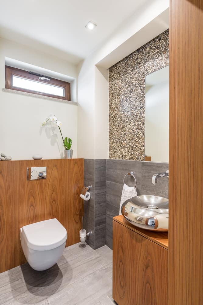 large powder room with wood accents and round silver sink