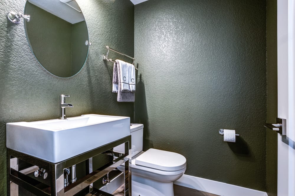 modern green wall bathroom with white sink vanity
