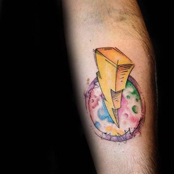 Power Rangers lightning bolt tattoo over a colorful watercolor-style moon, blending bold outlines with soft, cosmic shades on the forearm.
