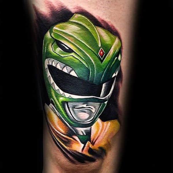 Vibrant Green Ranger helmet tattoo with fierce expression, smooth highlights, and a bold black and red background swirl.