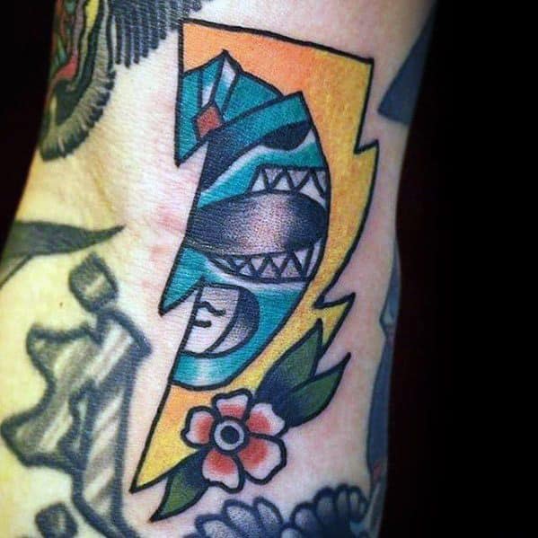 Traditional-style tattoo of the Blue Ranger inside a yellow lightning bolt, accented with bold outlines and a small flower at the base.