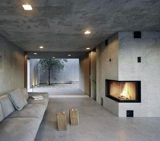 Modern precast concrete fireplace in a minimalist living space with an open courtyard view.