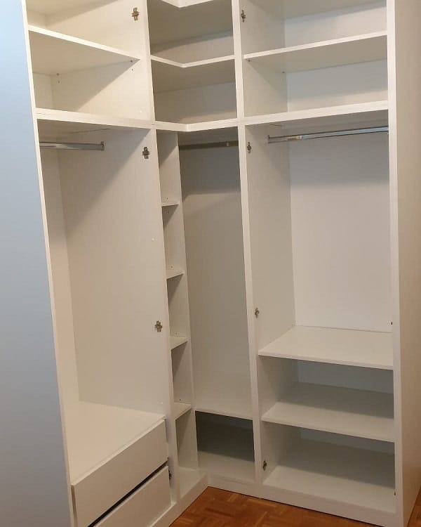 Empty white walk-in closet with shelving and hanging rods.