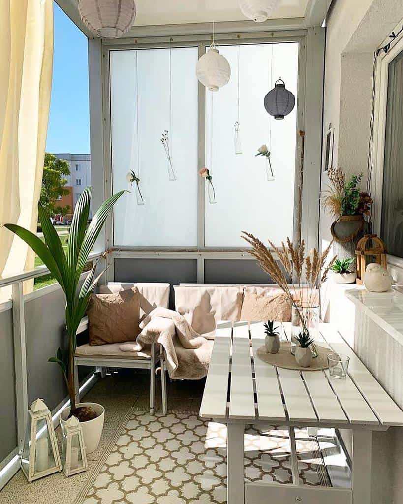 Small modern patio with white furniture, hanging lanterns, and plants for a minimalist look.