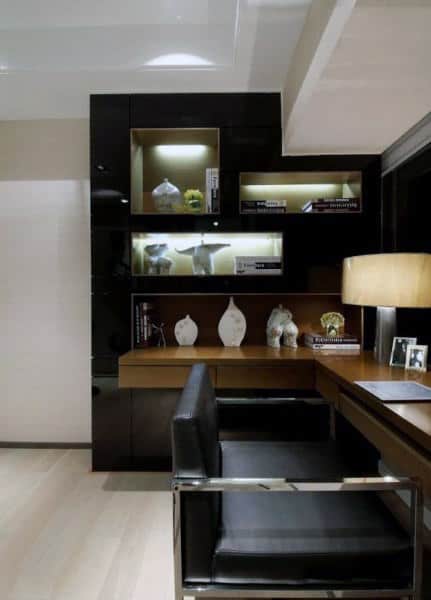 Modern home office with black shelves, decorative items, a chair, and desk with a lamp in minimalist design