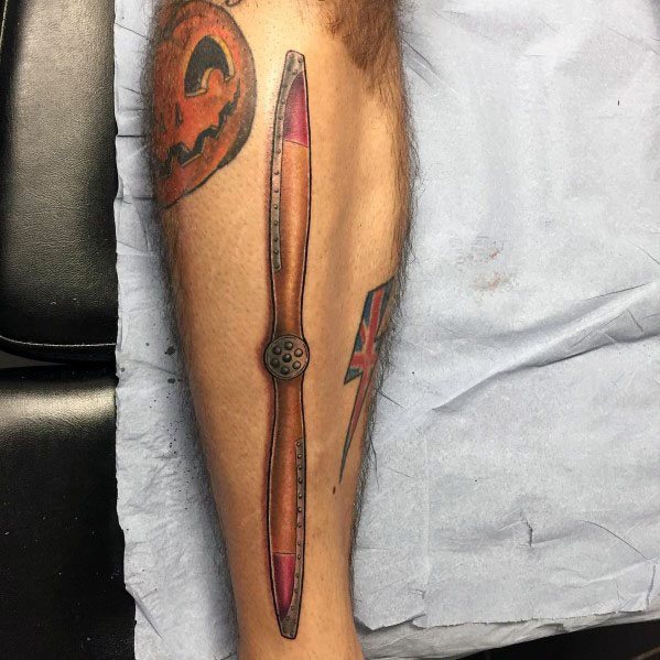 Color forearm tattoo of a vintage wooden propeller with red-tipped blades, featuring detailed shading and a realistic aviation-inspired design.