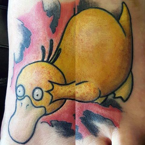 Dynamic Psyduck tattoo in a diving pose with a splash of red and black background, inked across the top of a man's foot.