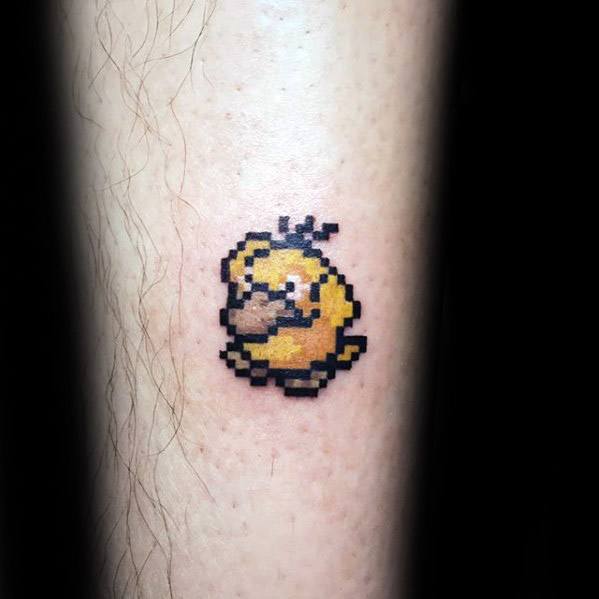 Retro-style Psyduck tattoo in pixel art design, inspired by classic video games, placed on a man's lower leg.