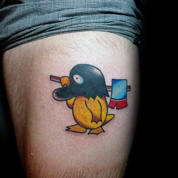 Funny Psyduck tattoo dressed as a penguin, carrying a bindle with a red and blue flag, inked on a man's thigh.