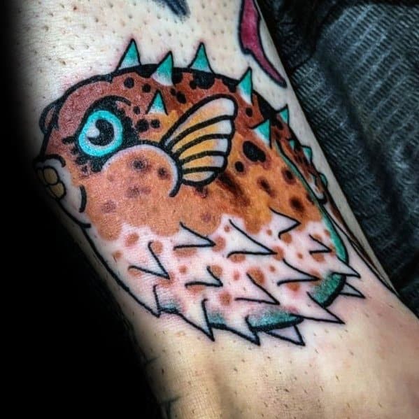 Traditional pufferfish tattoo with bold black outlines, vibrant orange and teal hues, and sharp spikes, creating a striking and dynamic design.
