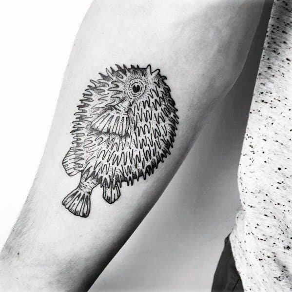 Minimalist black ink pufferfish tattoo with fine line details and a hand-drawn aesthetic, creating a simple yet artistic design.