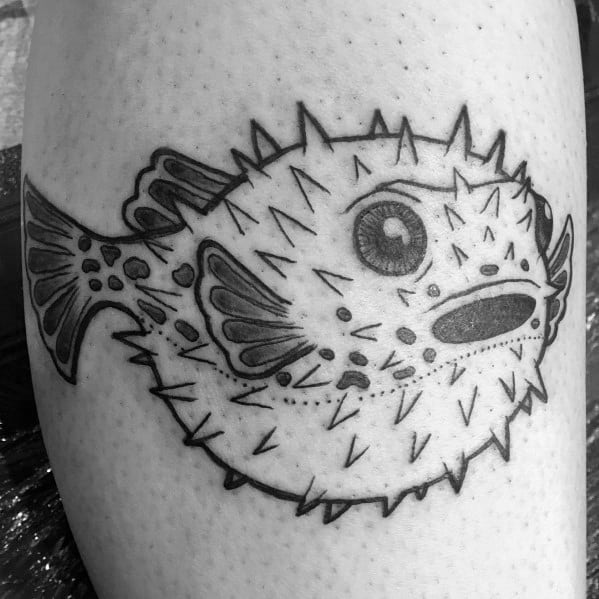Black and grey pufferfish tattoo with bold outlines, fine dot shading, and intricate details, creating a classic and expressive design.
