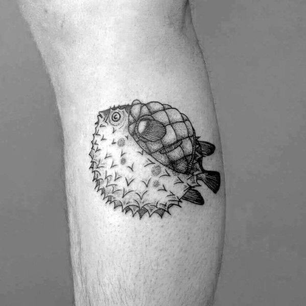 Black and grey pufferfish tattoo with fine dot shading and a turtle shell detail, blending marine life elements into a unique design.