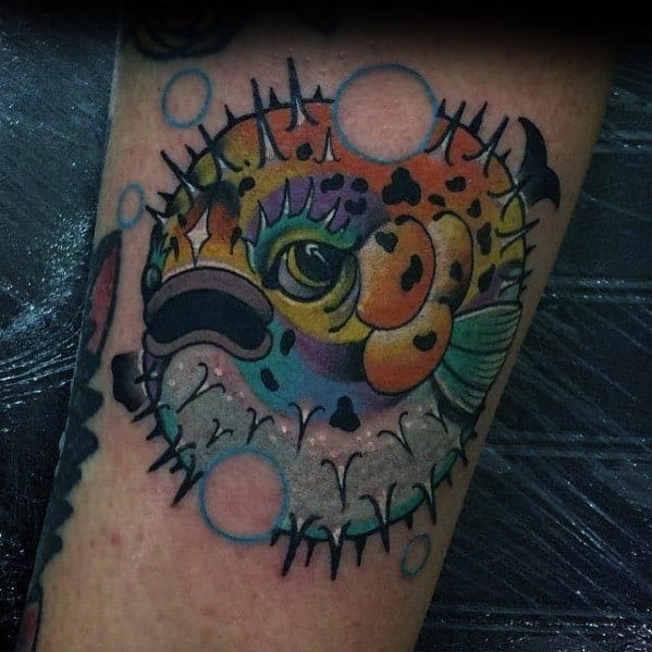 Vibrant pufferfish tattoo with bold colors, intricate shading, and floating bubbles, creating a dynamic and eye-catching underwater design.