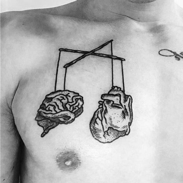 Minimalist puppet tattoo of a brain and heart hanging from strings on a crossbar, symbolizing the balance between logic and emotion.