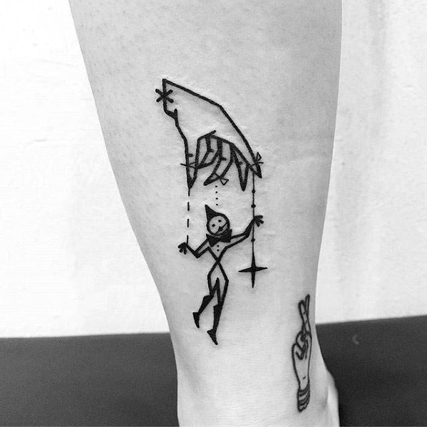 Simple linework puppet tattoo of a hand controlling a playful jester marionette with a star, giving off a whimsical and minimalist vibe.