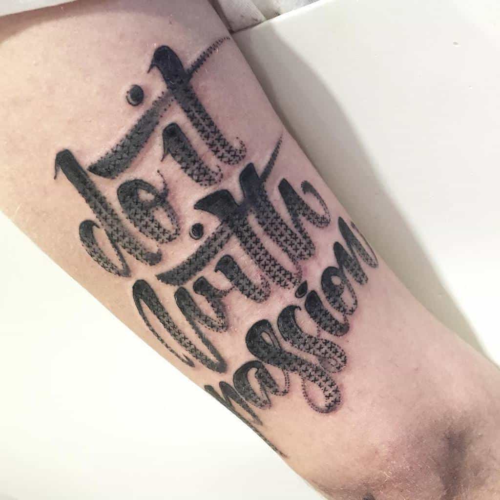Cross-stitch style tattoo of 'Do it with passion' in bold, embroidered lettering, creating a textured and handcrafted effect
