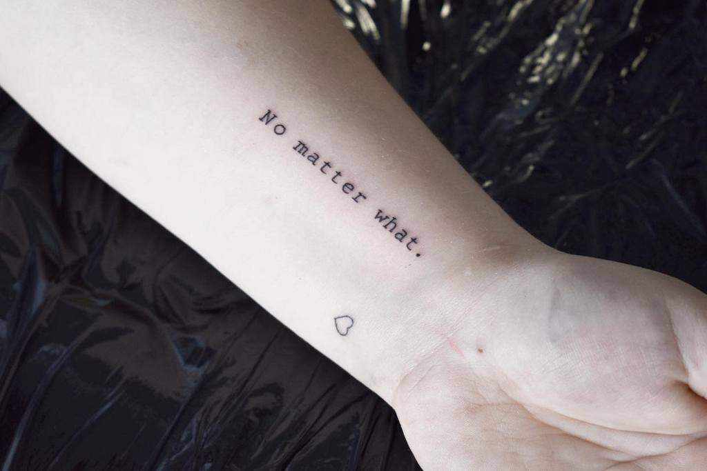 Forearm tattoo reads "No matter what." with a small heart outline below it