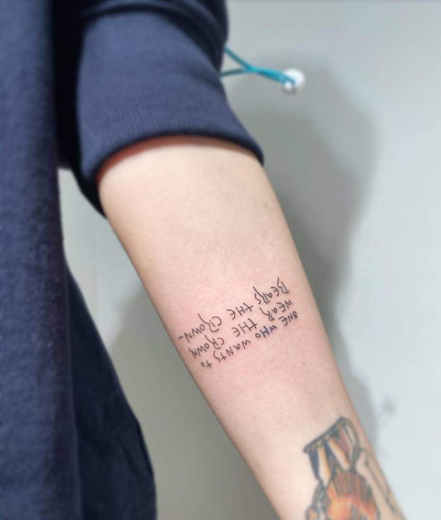 Forearm tattoo with cursive text on a woman's arm