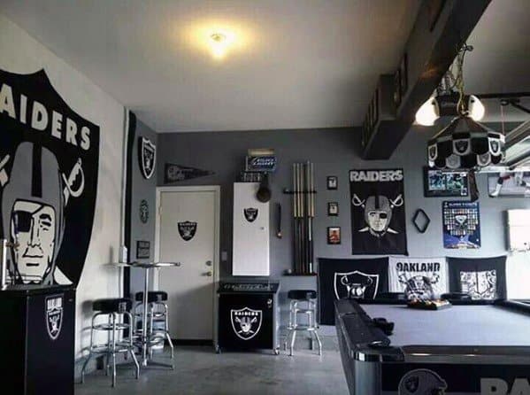 Room decorated with Raiders memorabilia, including banners, posters, and a pool table