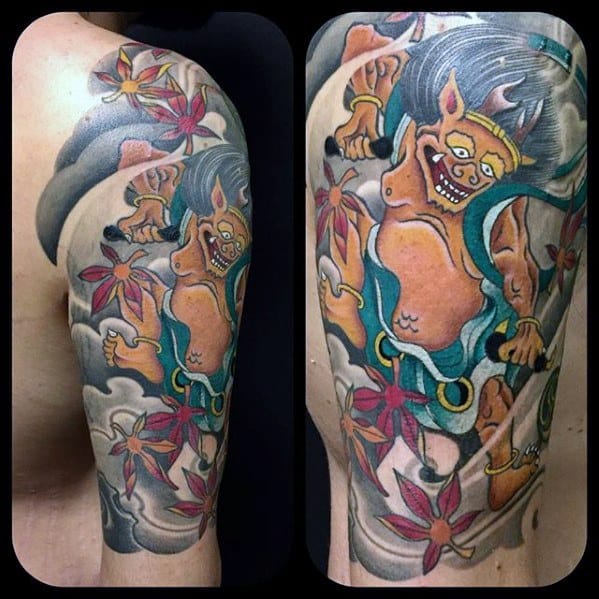 Colorful Raijin upper arm tattoo with playful thunder god, flowing hair, vibrant flowers, and swirling clouds in Japanese style.