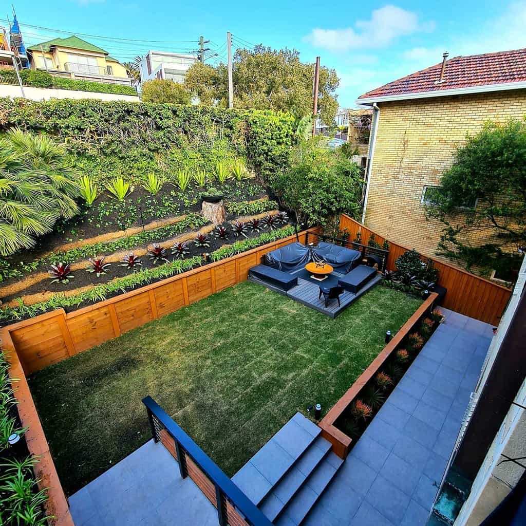 large backyard raised tiered garden paver patio wood deck and fence