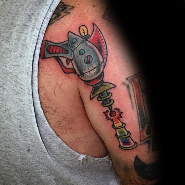 Colorful retro ray gun tattoo on the upper arm, featuring a classic sci-fi design with metallic shading, vibrant accents, and a futuristic energy beam.