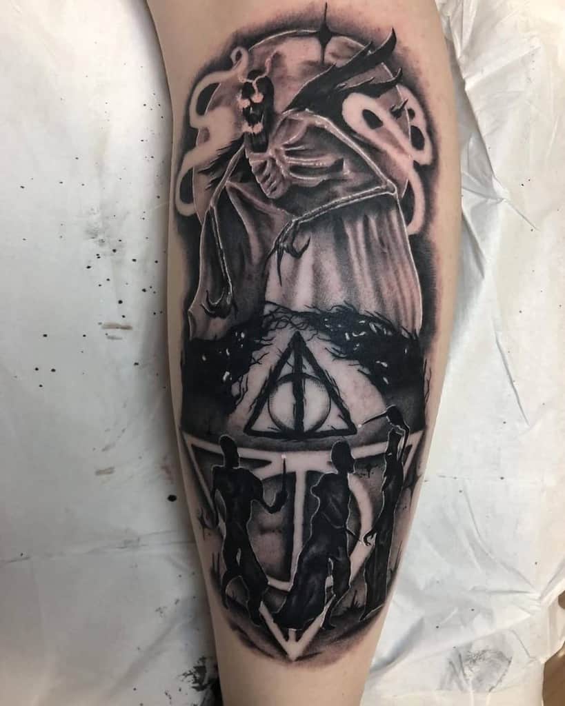 Dark, detailed Deathly Hallows tattoo featuring the Tale of the Three Brothers, a hooded Grim Reaper, and silhouettes in black ink.