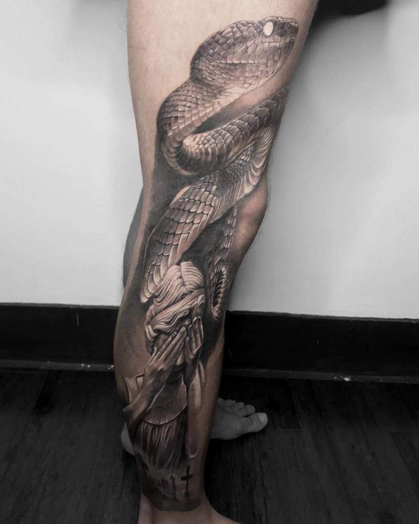 Realistic leg sleeve tattoo of a large snake and a woman covering their face with lot of cross below