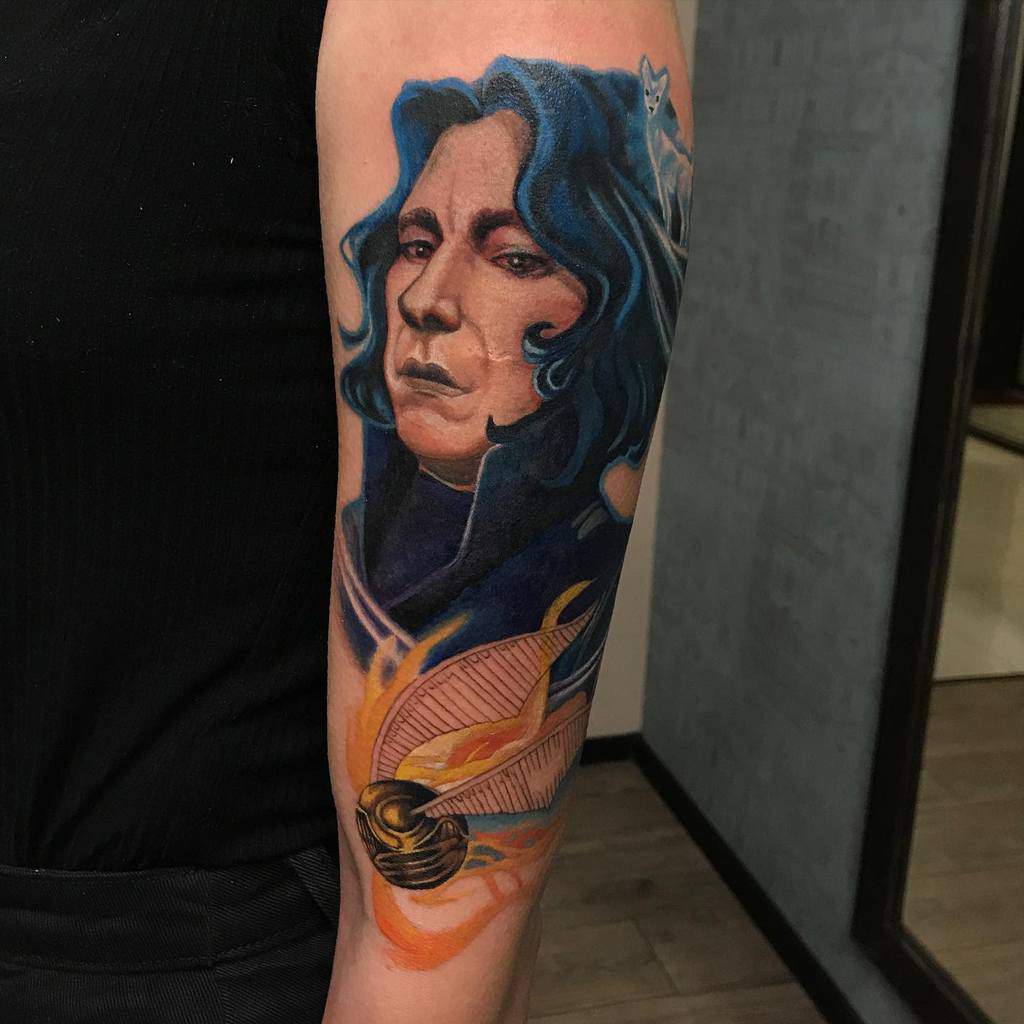Vibrant tattoo of Severus Snape with flowing blue hair, a silver doe Patronus, and a fiery Golden Snitch at the bottom.