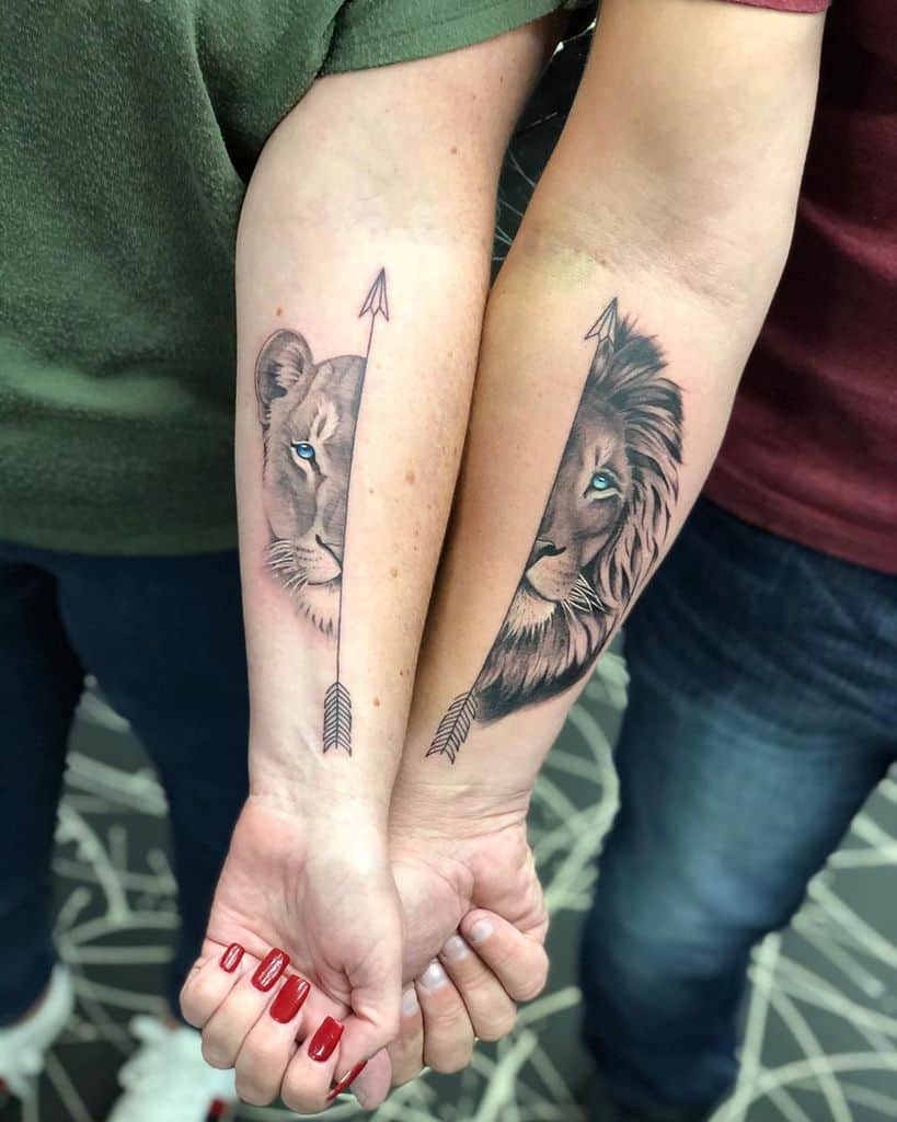 Matching forearm tattoos featuring a lioness and lion, each with a half-face design split by a black arrow, symbolizing unity and strength.