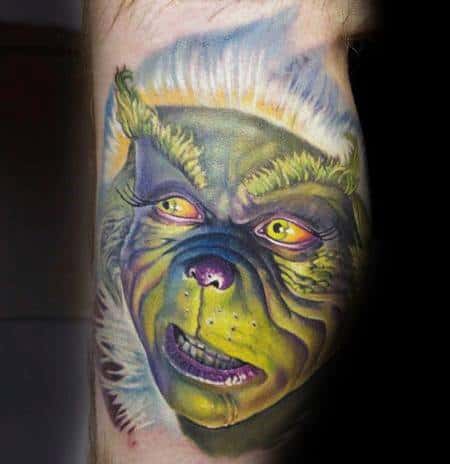Vibrant and detailed Grinch face, capturing his mischievous and angry expression with rich green, yellow, and purple hues in a dynamic tattoo design.