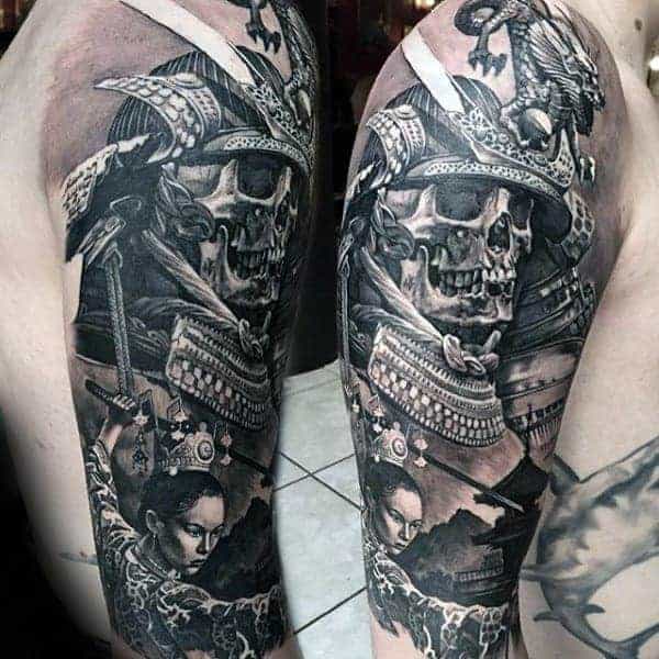 Detailed black and grey tattoo of a samurai skull and woman's face on an upper arm