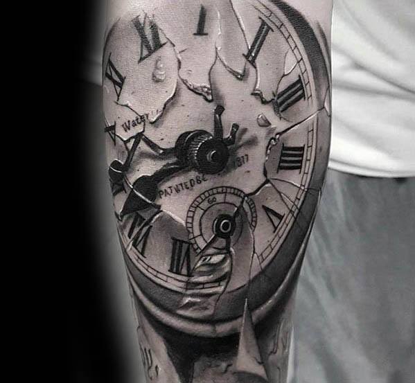 Realistic black and grey tattoo of a cracked vintage clock with Roman numerals, symbolizing time breaking apart or fading away.