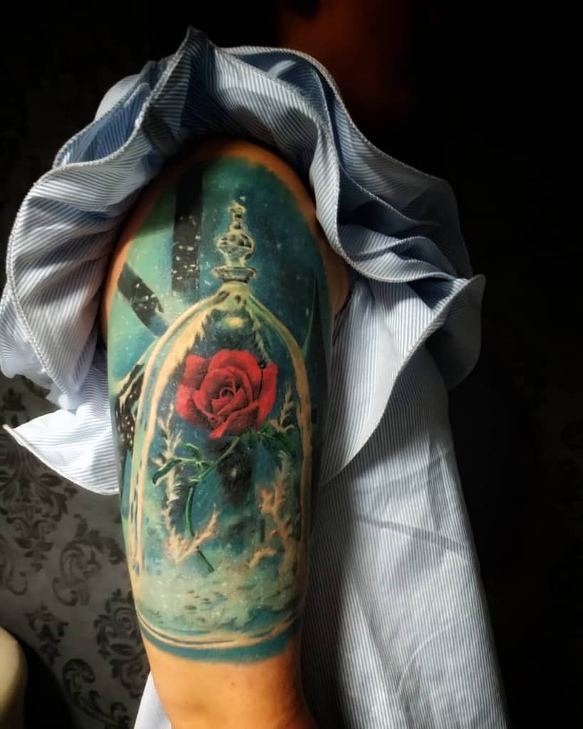 A realistic Beauty and the Beast rose tattoo inside a glass dome with a magical, snowy background and vibrant red petals