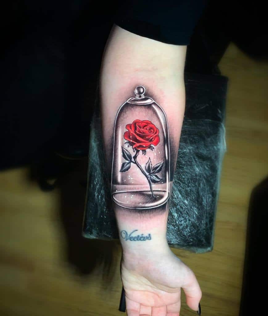 Realistic forearm tattoo of a red rose encased in a glass dome, inspired by 'Beauty and the Beast' with intricate shading.