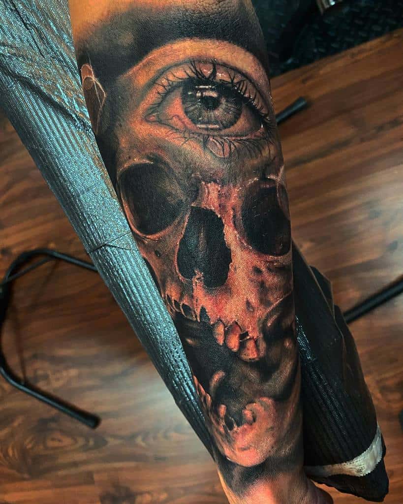 Tattoo featuring a realistic skull and eye design on a forearm