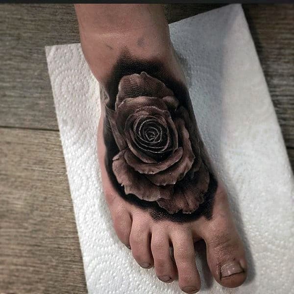 Foot tattoo of a large, detailed black rose