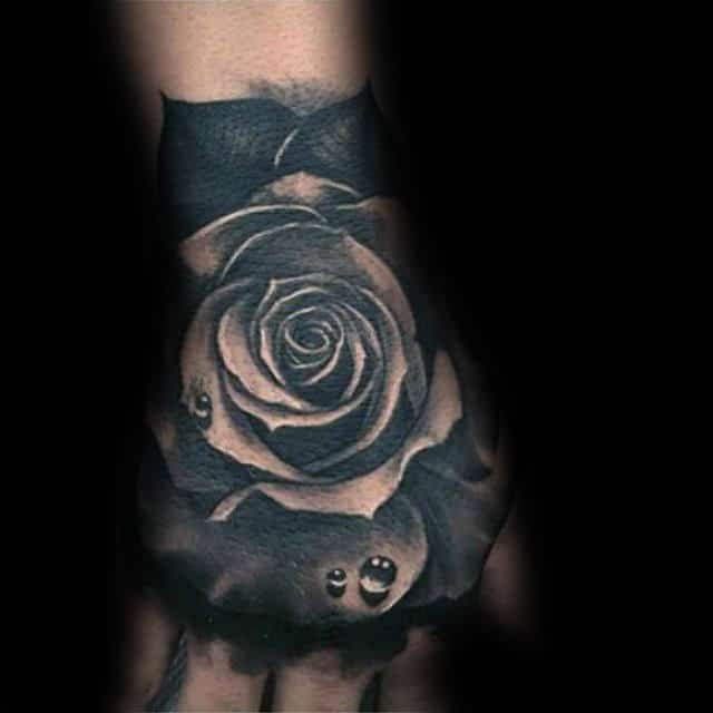 Black and white rose tattoo on a hand