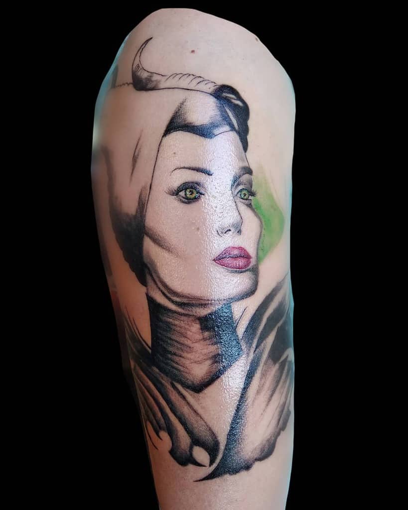 Detailed Maleficent tattoo with vivid green eyes, soft shading, and striking realism capturing her iconic elegance and mystique