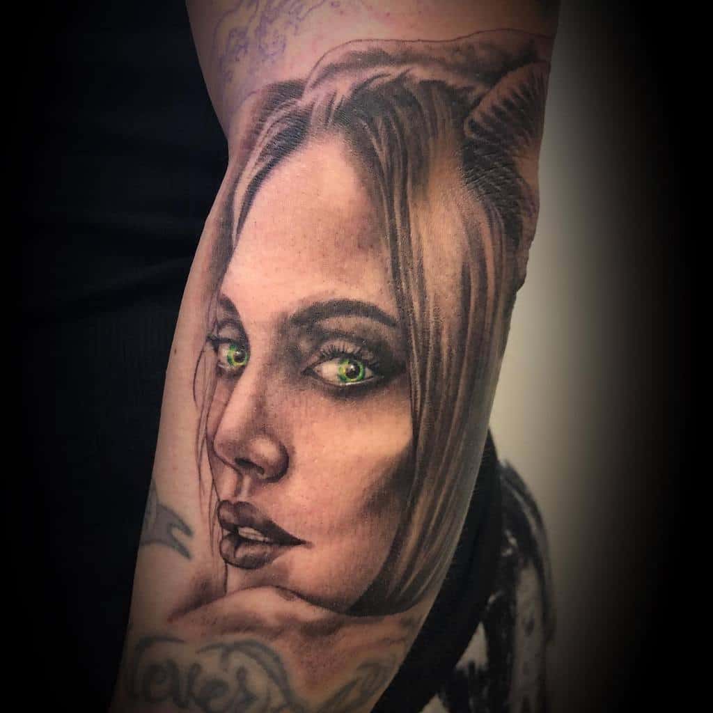 Hyper-realistic Maleficent tattoo with piercing green eyes and smooth shading, embodying her intense and mysterious allure