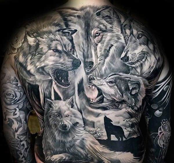 Tattoo of a pack of wolves on a person's back, featuring realistic depictions and a howling wolf silhouette