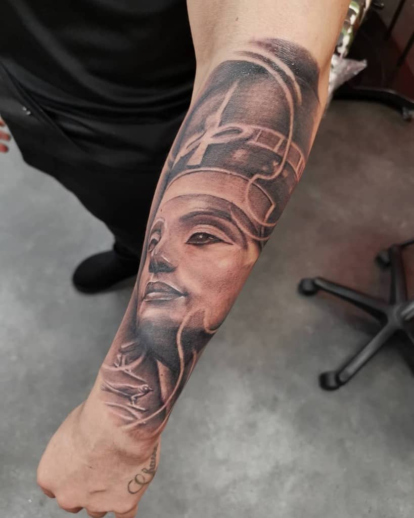 Forearm tattoo of Nefertiti, an ancient Egyptian queen with a detailed, realistic design