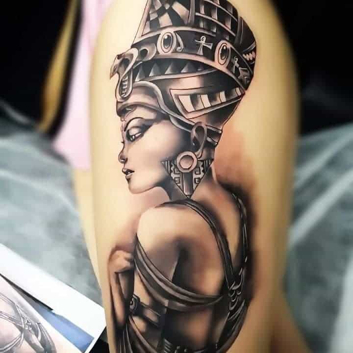 A detailed tattoo of Nefertiti with an ancient Egyptian headdress on an arm