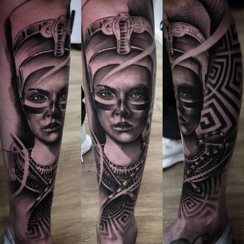 Nefertiti-inspired realistic tattoo of an ancient warrior woman on a leg, with intricate armor and geometric patterns