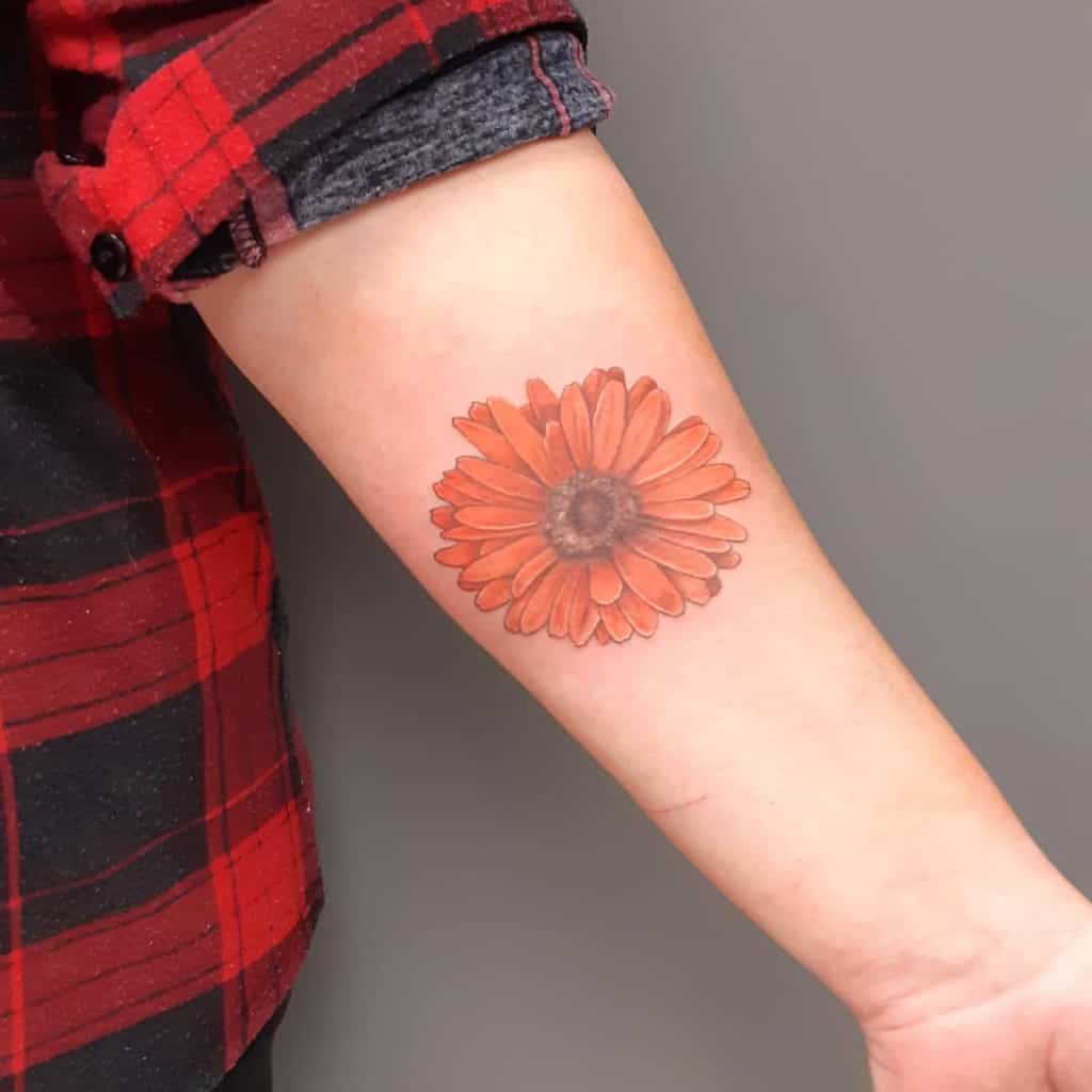 Forearm tattoo realistic orange color daisy