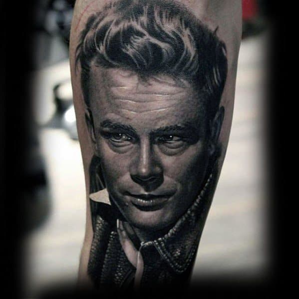 Hyper-realistic black and grey tattoo of James Dean in a collared jacket, with slicked-back hair and a confident, smirking expression.