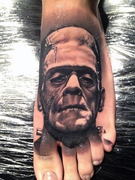 A realistic tattoo of Frankenstein's monster's face inked on a foot